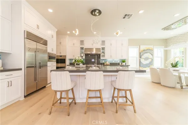 a kitchen with a dining table chairs refrigerator and cabinets