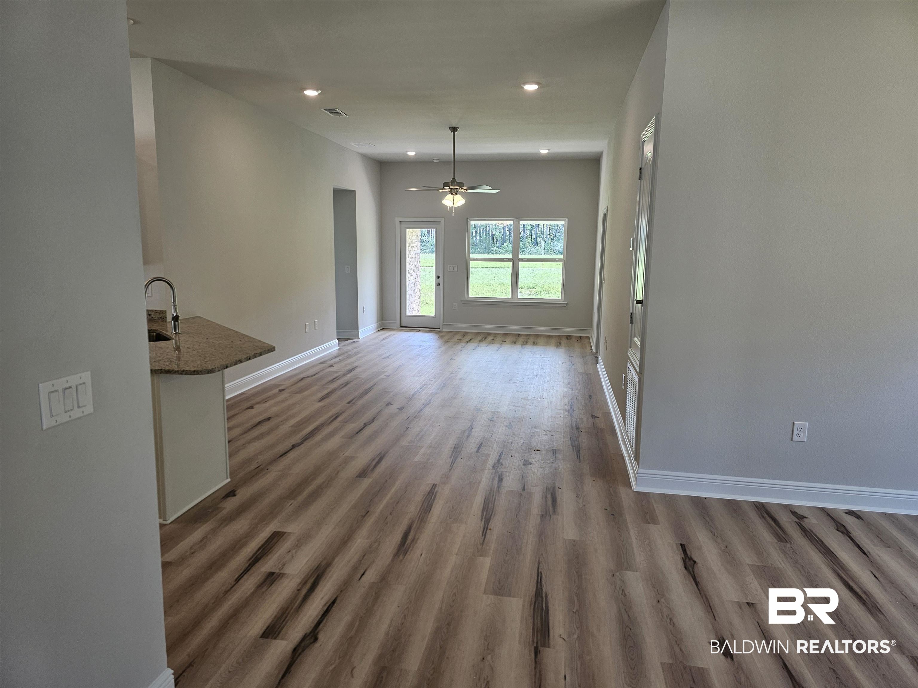 650 Revere Street Foley, AL 36535 - Photo 2 of 34 Empty room with light wood-type flooring, ceiling fan, and sink