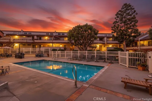 a view of a swimming pool with a patio and wooden fence