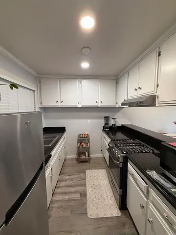 a kitchen with granite countertop stainless steel appliances and white cabinets