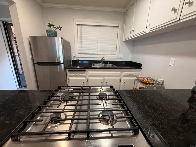 a kitchen with kitchen island a counter space a stove and a refrigerator
