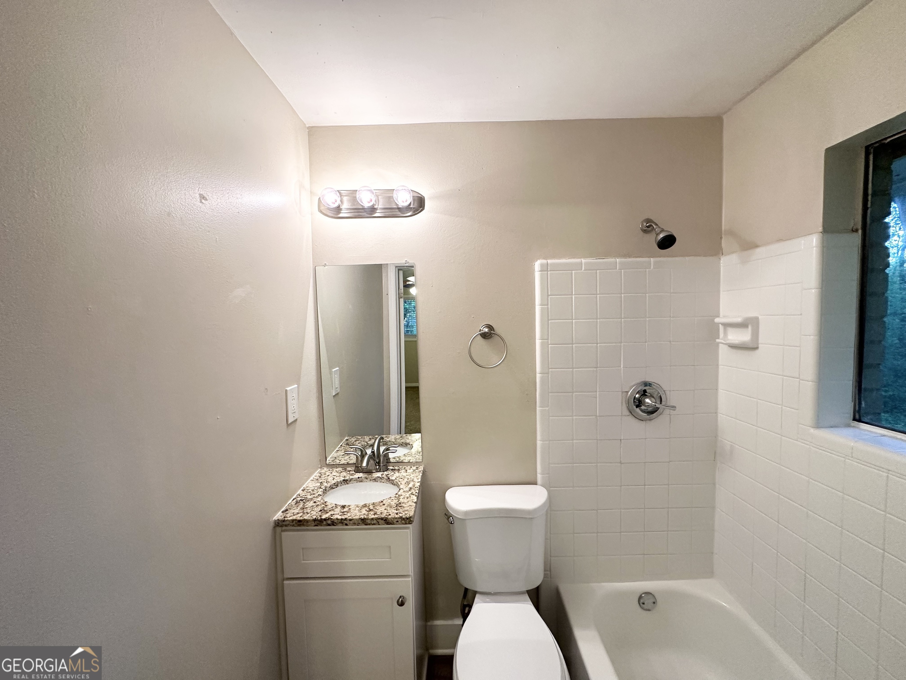 4505 Wonder Valley Trail Decatur, GA 30034 - Photo 17 of 24 a bathroom with a granite countertop toilet a sink and shower
