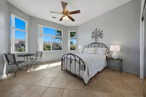 a bedroom with a bed and a table chair