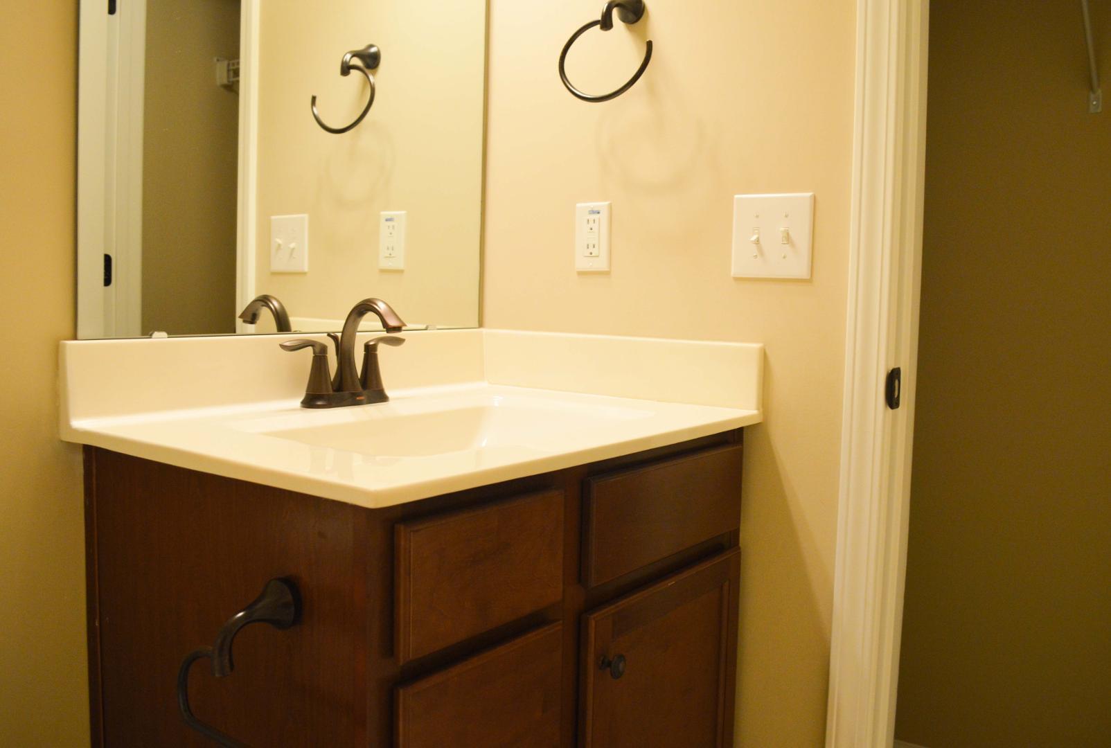 720 Wickham Ridge Road Apex, NC 27539 - Photo 18 of 24 a bathroom with a sink and a mirror