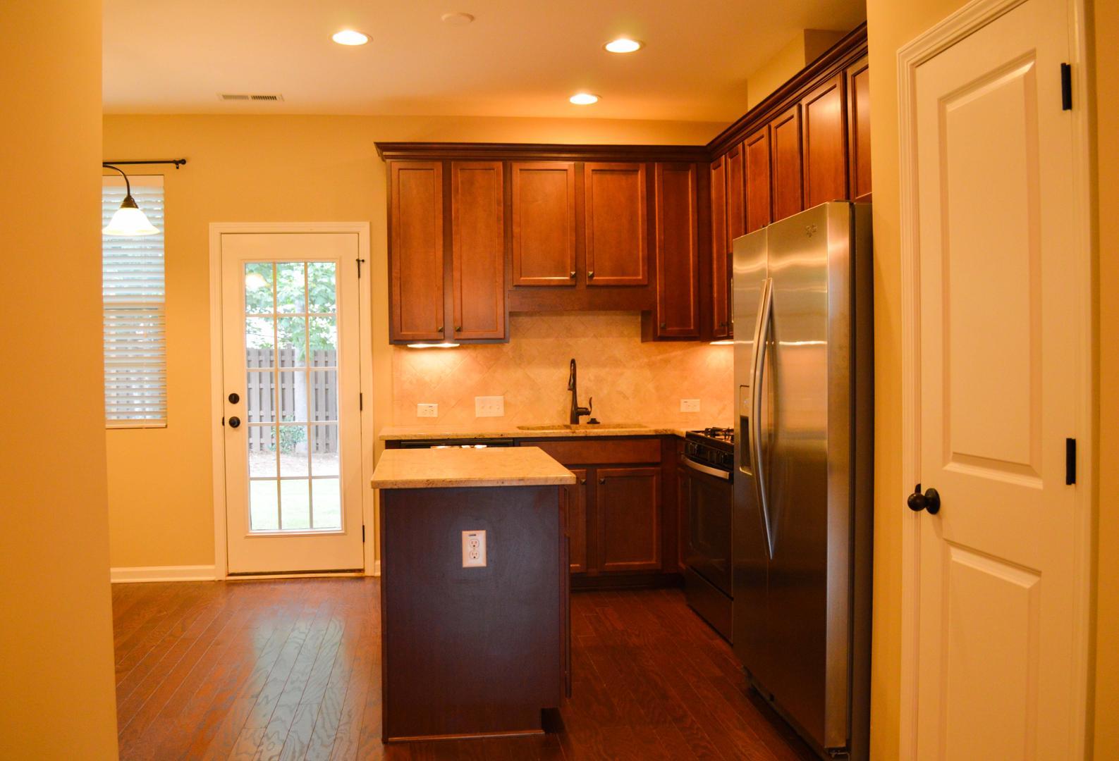 720 Wickham Ridge Road Apex, NC 27539 - Photo 7 of 24 a kitchen with stainless steel appliances granite countertop a refrigerator a sink and wooden cabinets