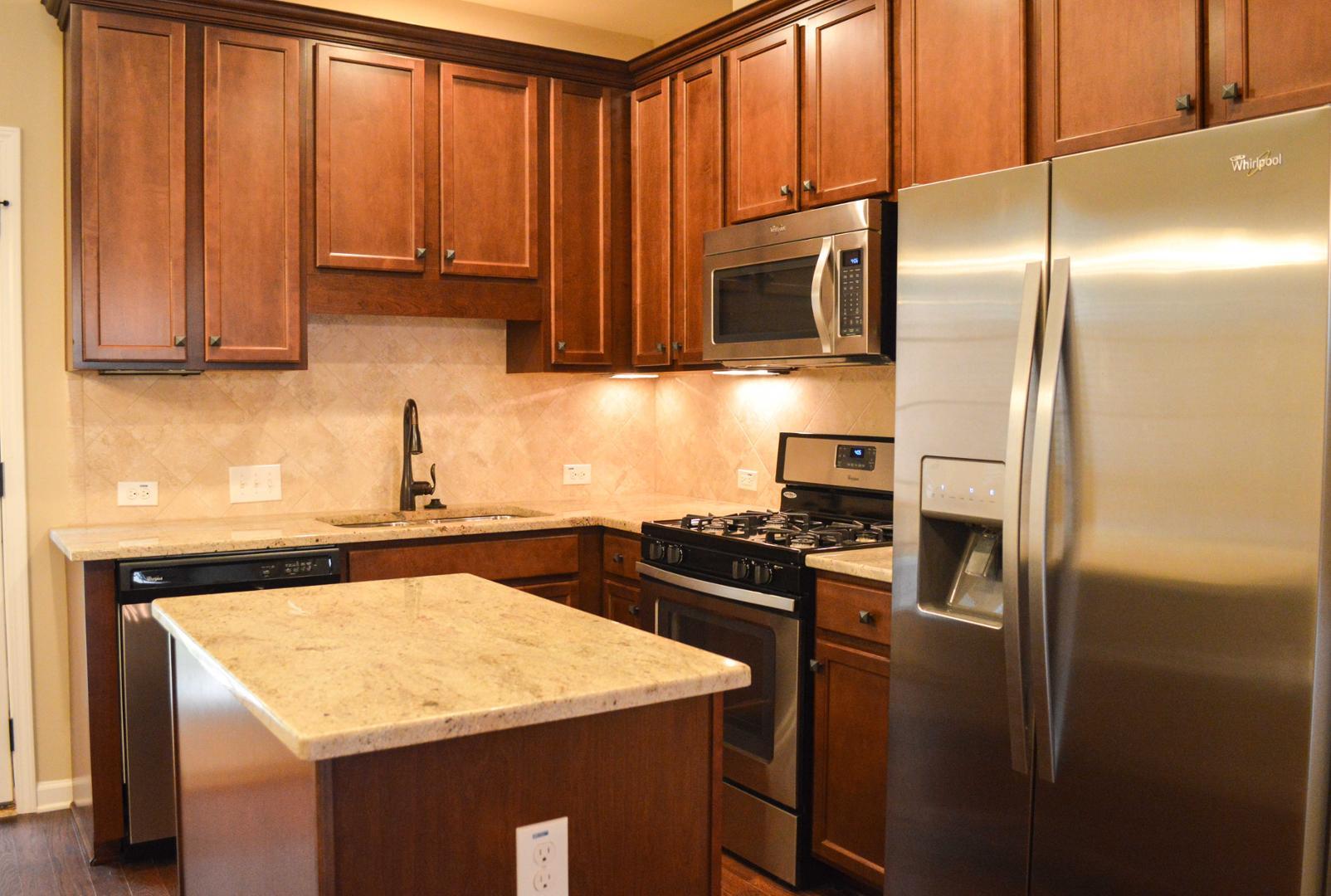 720 Wickham Ridge Road Apex, NC 27539 - Photo 8 of 24 a kitchen with stainless steel appliances granite countertop a refrigerator a stove and a sink with wooden floor