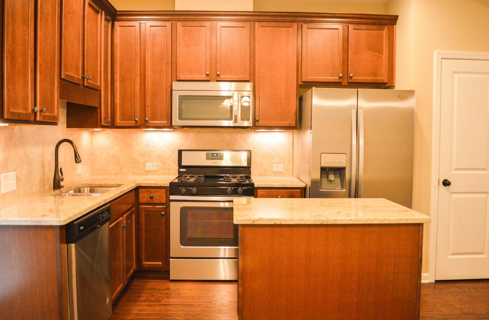 720 Wickham Ridge Road Apex, NC 27539 - Photo 9 of 24 a kitchen with stainless steel appliances granite countertop a stove a sink and a refrigerator