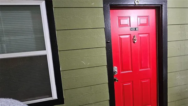 a view of an empty room and a kitchen