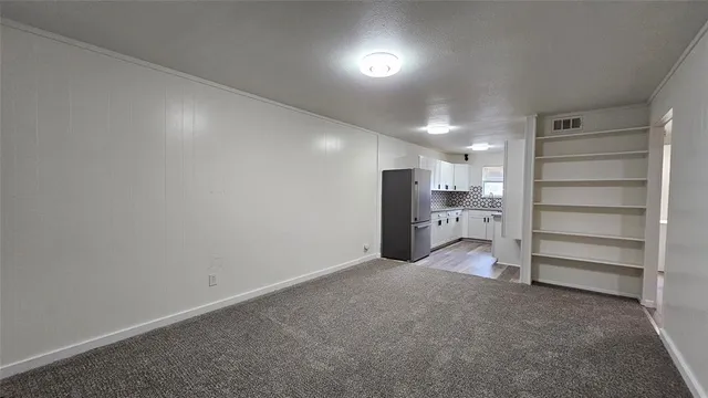 an empty room with bookshelf and natural light