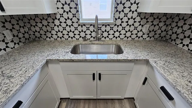 a kitchen with granite countertop a refrigerator and a sink