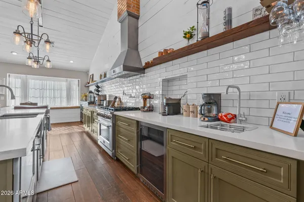 a kitchen with stainless steel appliances granite countertop a sink a stove and refrigerator