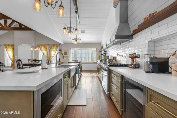 a dining hall with stainless steel appliances granite countertop a dining table and chairs with wooden floor