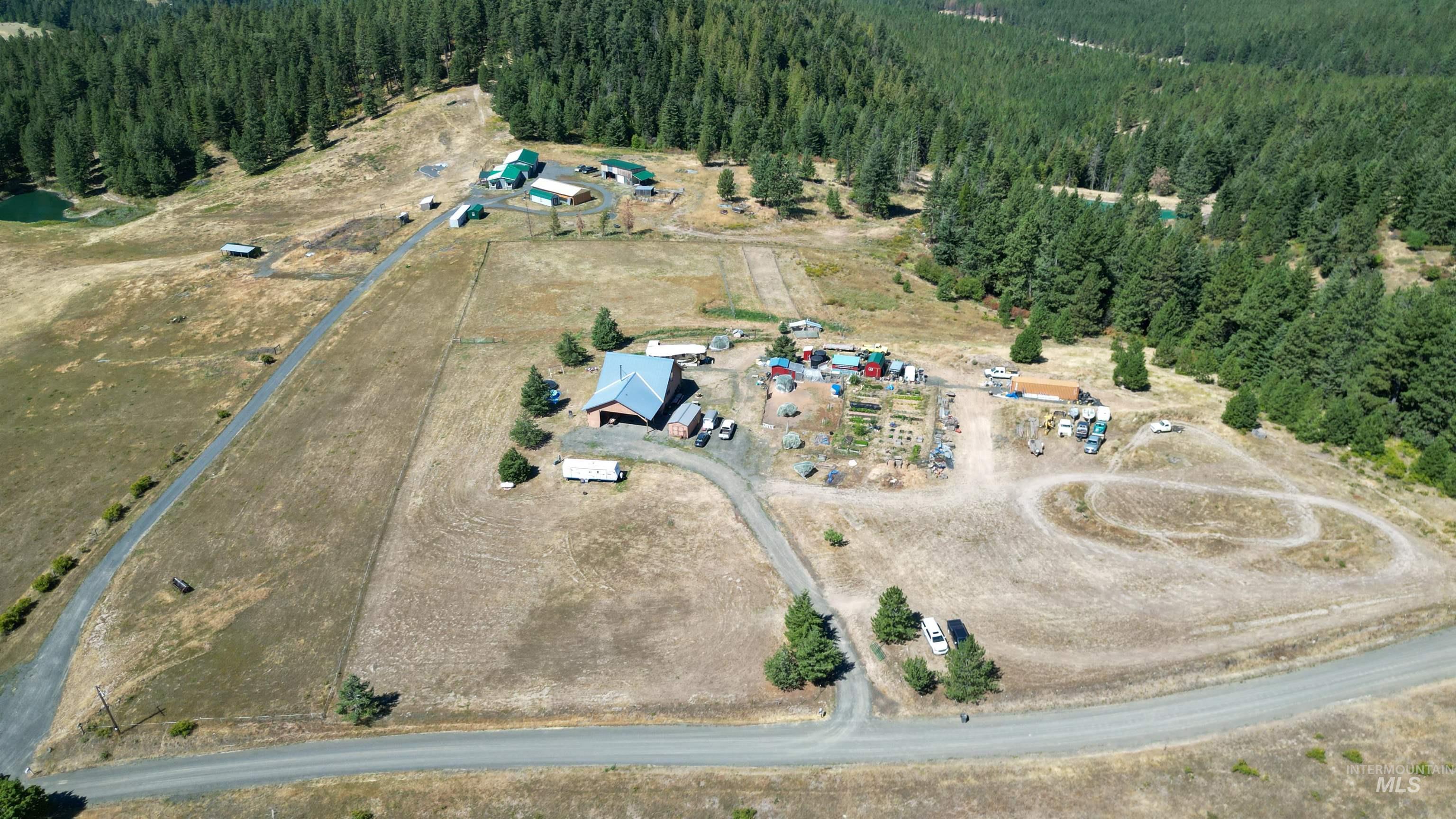 1321 Gold Hill Road Princeton, ID 83857 - Photo 23 of 29 Expansive property featuring a large metal-roofed structure, extensive open land, and surrounding wooded areas