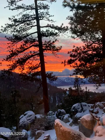 a front view of a house with a yard and lake view