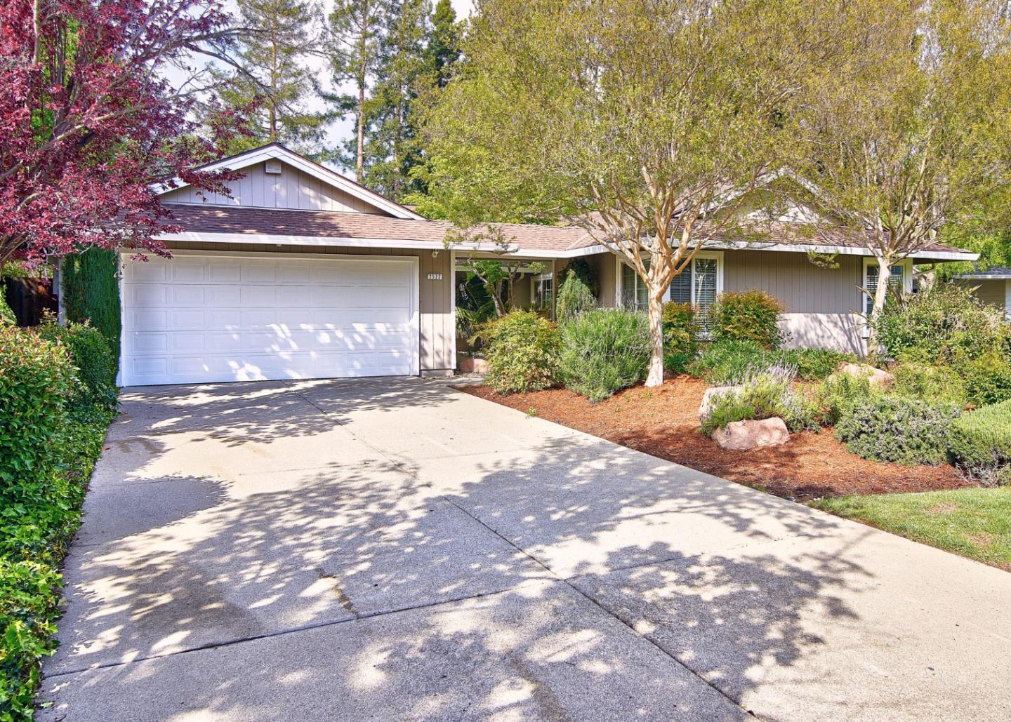 a front view of a house with a yard and potted plants