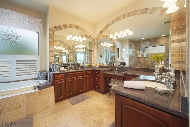 a bathroom with a granite countertop sink a bathtub and shower
