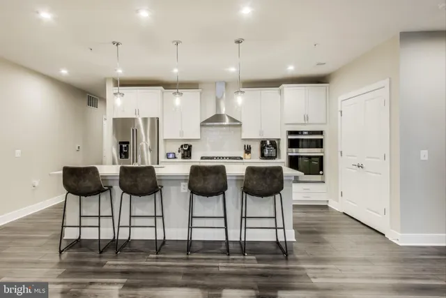 a kitchen with stainless steel appliances kitchen island granite countertop a dining table and chairs