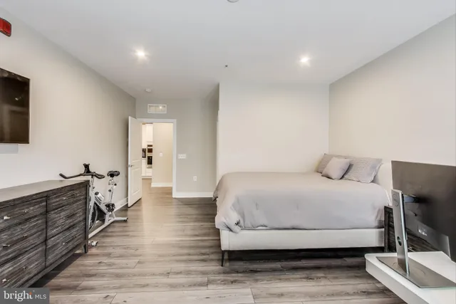 a spacious bedroom with a bed and a dresser