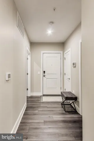 a view of a room with wooden floor and a bench