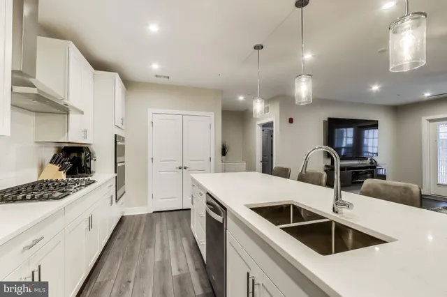 a kitchen with a sink a counter space appliances and cabinets
