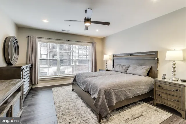 a bedroom with a large bed and a flat tv screen