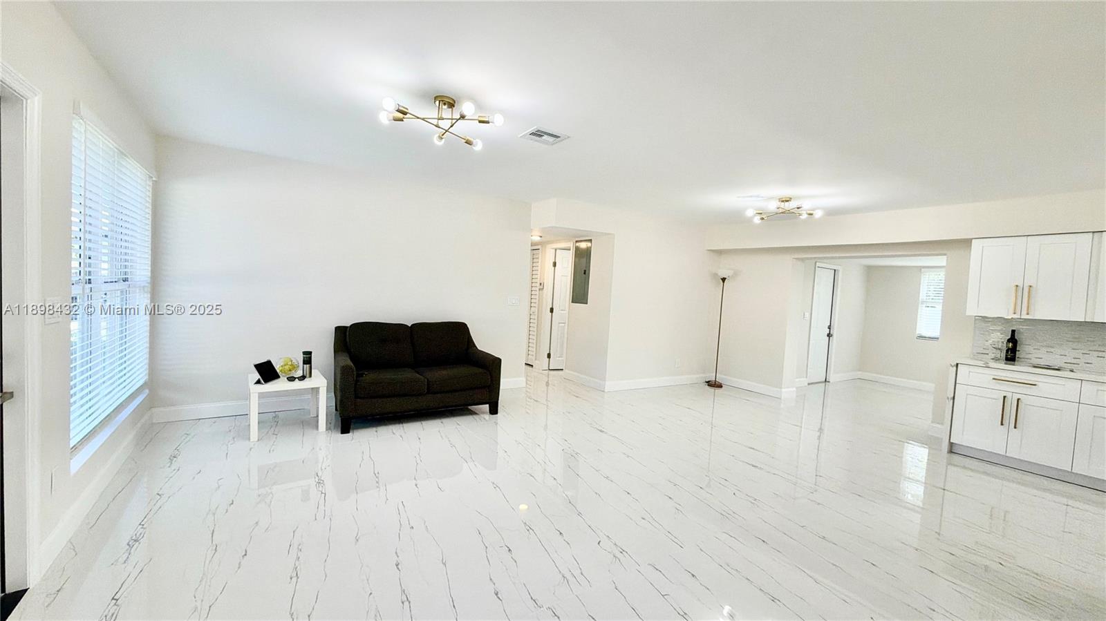 124 Harvard Road West Park, FL 33023 - Photo 15 of 75 a living room with furniture and a chandelier