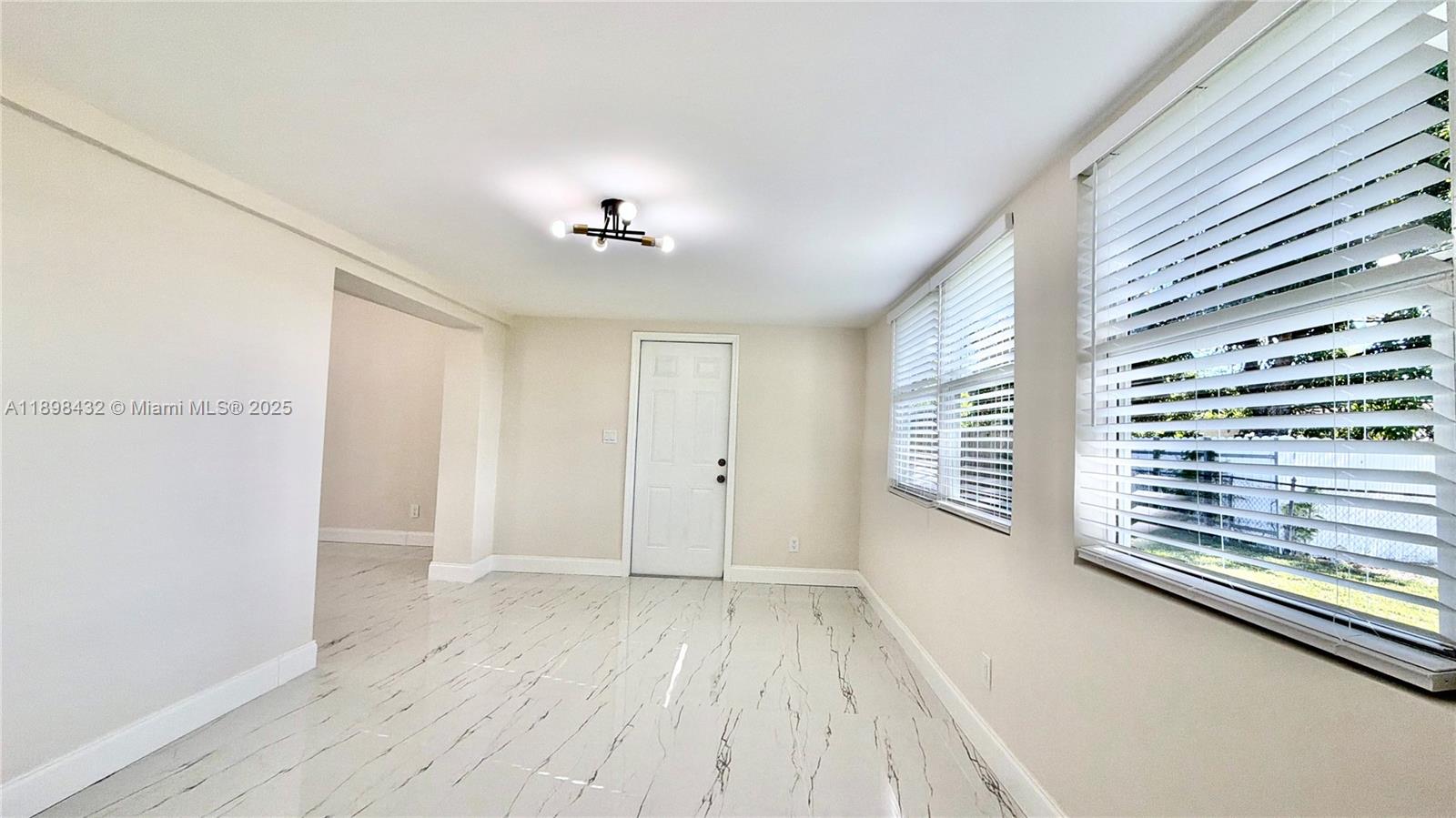 124 Harvard Road West Park, FL 33023 - Photo 20 of 75 a view of an empty room with a window and wooden floor