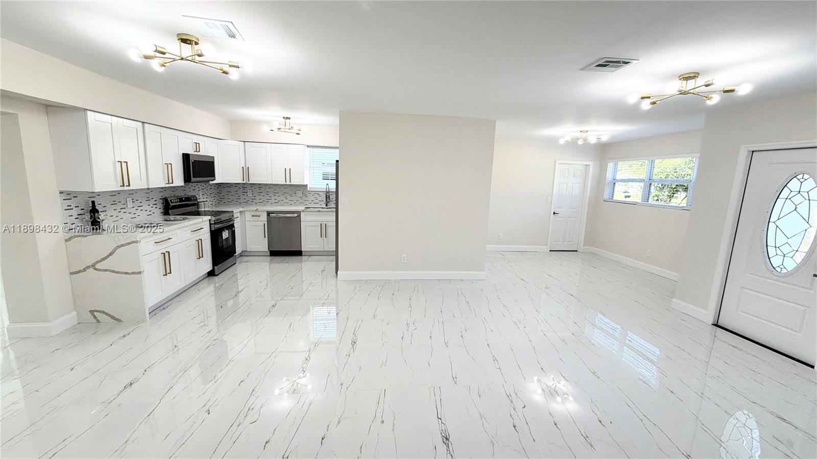 124 Harvard Road West Park, FL 33023 - Photo 23 of 75 a large white kitchen with a stove a sink dishwasher and a refrigerator with wooden floor