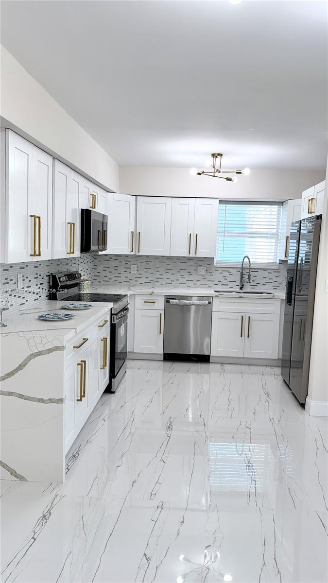 124 Harvard Road West Park, FL 33023 - Photo 24 of 75 a large kitchen with cabinets and stainless steel appliances