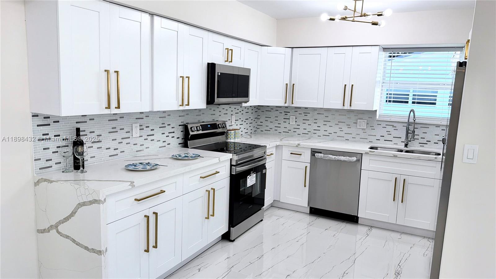 124 Harvard Road West Park, FL 33023 - Photo 25 of 75 a kitchen with white cabinets and white appliances