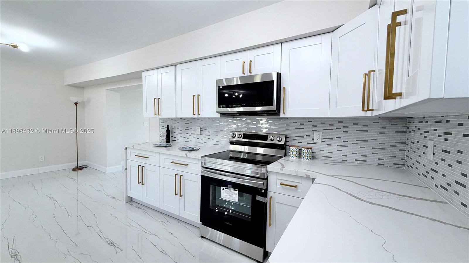 124 Harvard Road West Park, FL 33023 - Photo 27 of 75 a kitchen with stainless steel appliances a stove a sink and a microwave
