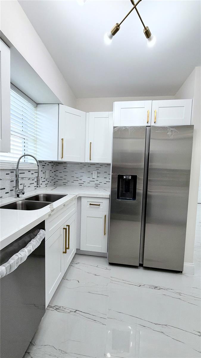124 Harvard Road West Park, FL 33023 - Photo 28 of 75 a kitchen with granite countertop white cabinets and white stainless steel appliances