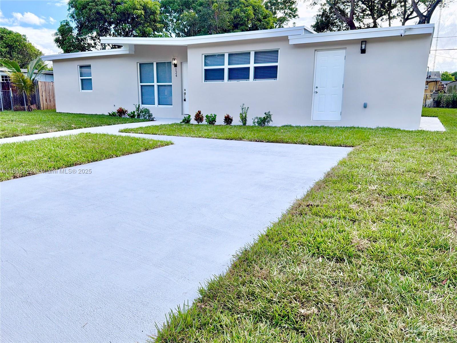 124 Harvard Road West Park, FL 33023 - Photo 3 of 75 a front view of a house with a yard and garage