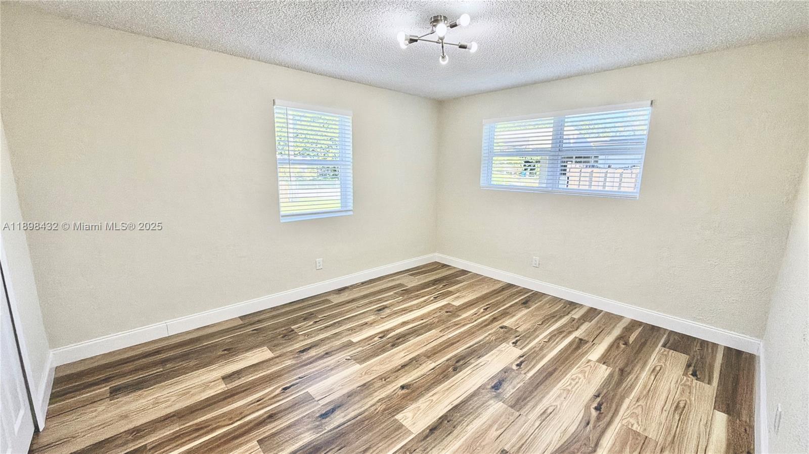124 Harvard Road West Park, FL 33023 - Photo 38 of 75 a view of a room with wooden floor and chandelier