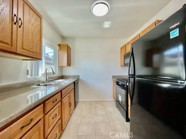 a kitchen with granite countertop a sink and stainless steel appliances
