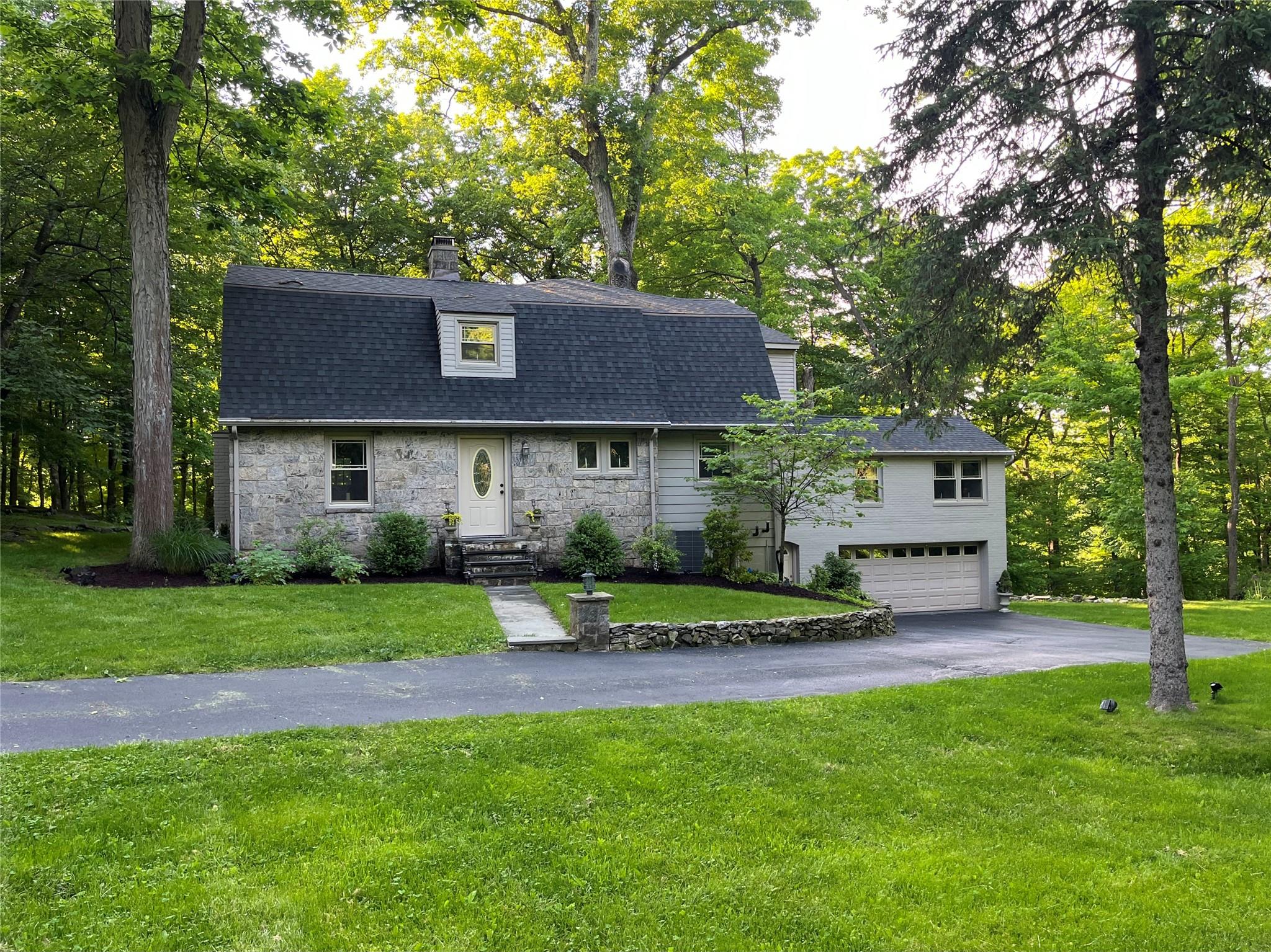 12 Seven Bridges Road Chappaqua, NY 10514 - Photo 1 of 1 View of front of home featuring a 2 car garage and front lawn.