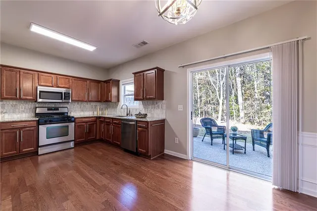 a kitchen with stainless steel appliances a refrigerator and a stove top oven