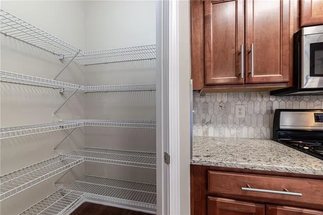 a kitchen with stainless steel appliances granite countertop wooden floors and granite counter tops