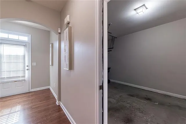 a view of an empty room with wooden floor fireplace and a window