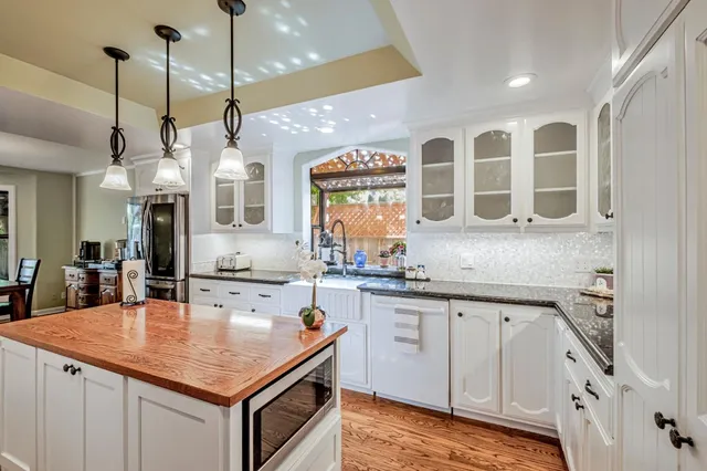 a kitchen with stainless steel appliances granite countertop a sink a stove and a refrigerator