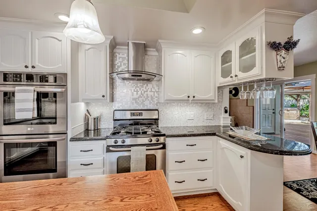 a kitchen with stainless steel appliances granite countertop a stove and cabinets