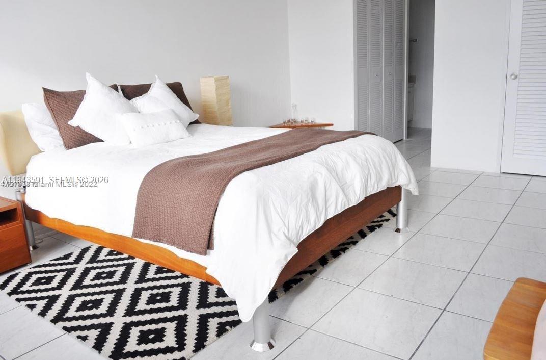 100 Lincoln Road, Unit 522 Miami Beach, FL 33139 - Photo 6 of 7 a bedroom with a bed and wooden floor