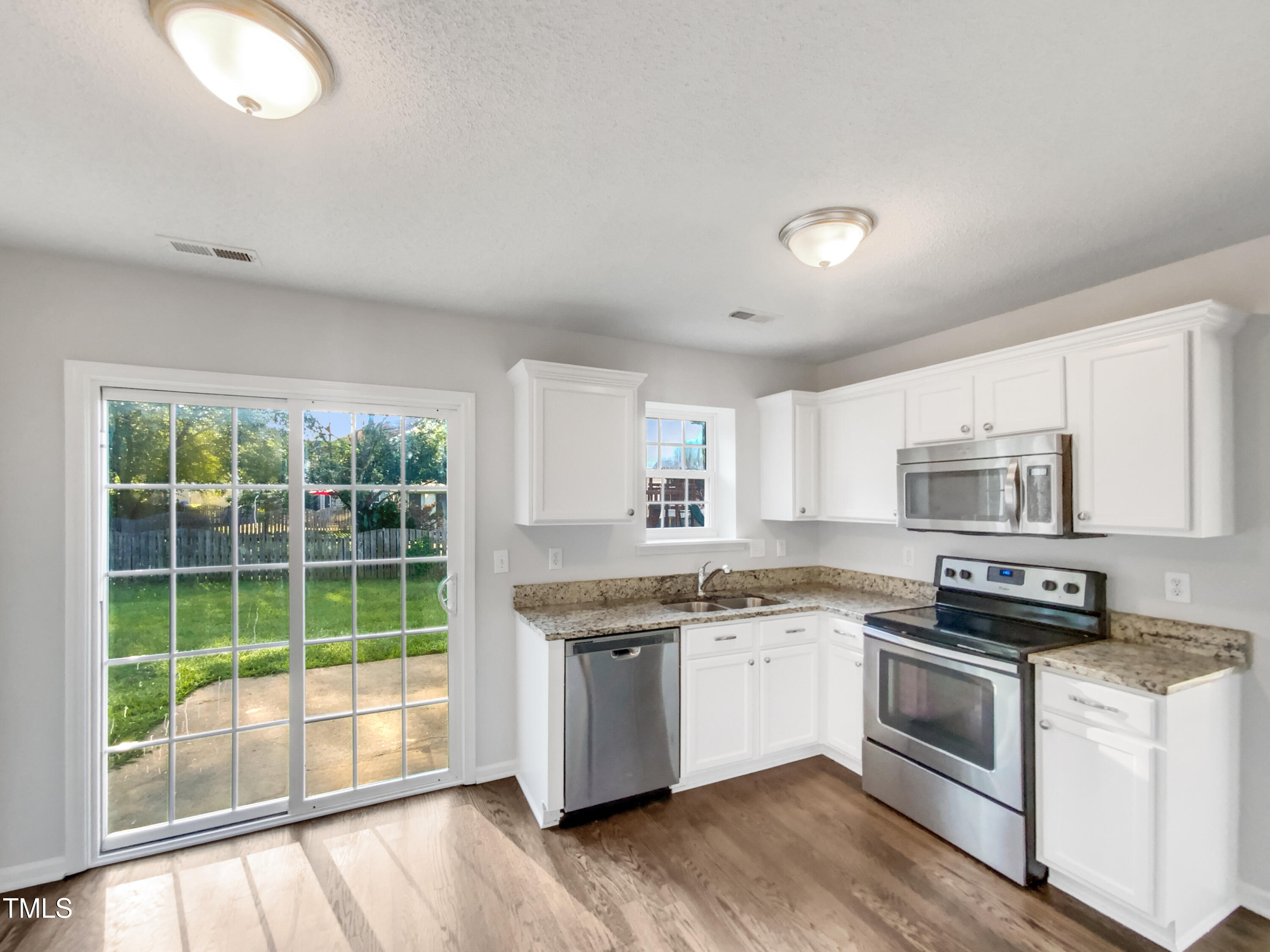 102 Spring Dove Lane Apex, NC 27539 - Photo 11 of 20 a kitchen with stainless steel appliances granite countertop a stove a sink and a microwave