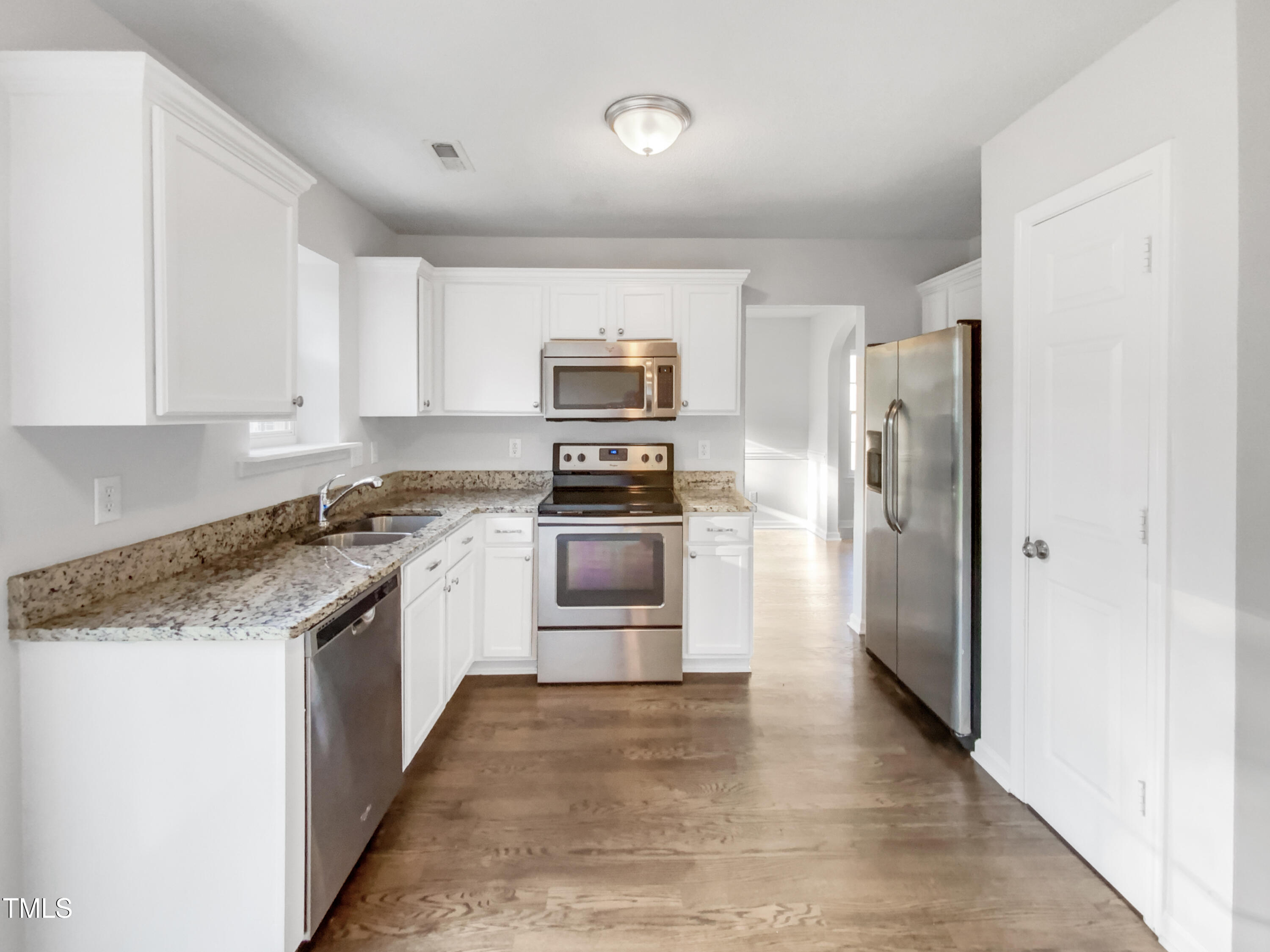 102 Spring Dove Lane Apex, NC 27539 - Photo 6 of 20 a kitchen with granite countertop a refrigerator and a stove top oven
