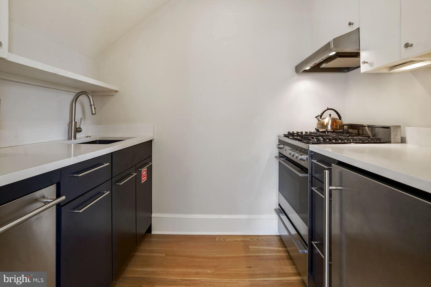3348 Prospect Street Northwest, Unit 3 Washington, DC 20007 - Photo 11 of 13 a kitchen with stainless steel appliances granite countertop a sink stove and refrigerator