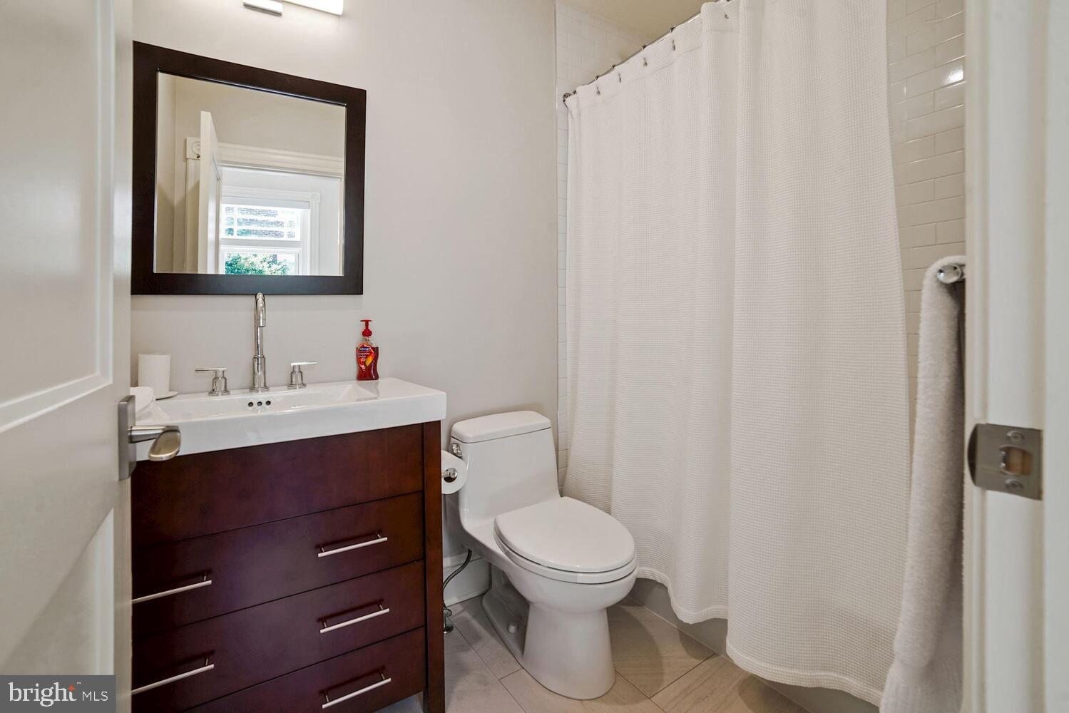 3348 Prospect Street Northwest, Unit 3 Washington, DC 20007 - Photo 12 of 13 a bathroom with a toilet a sink and mirror