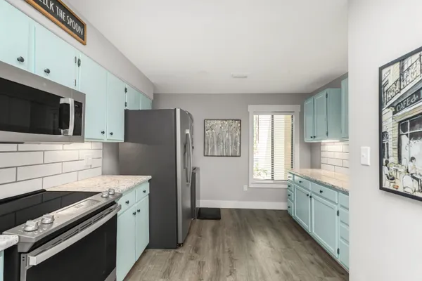 a kitchen view with granite countertop a sink and a wooden floor