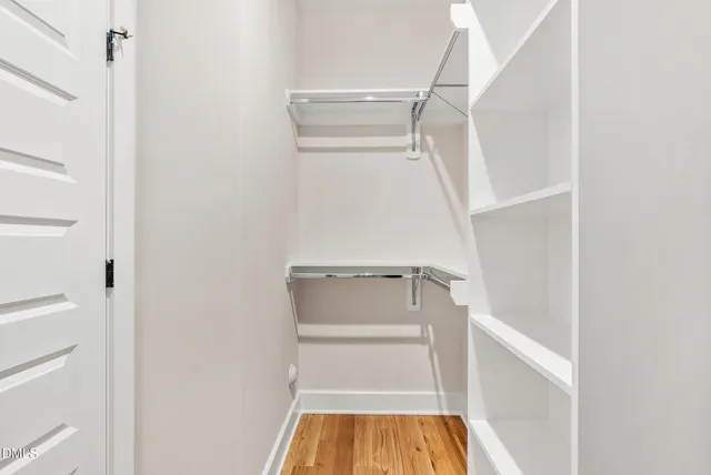 a view of walk in closet with empty racks