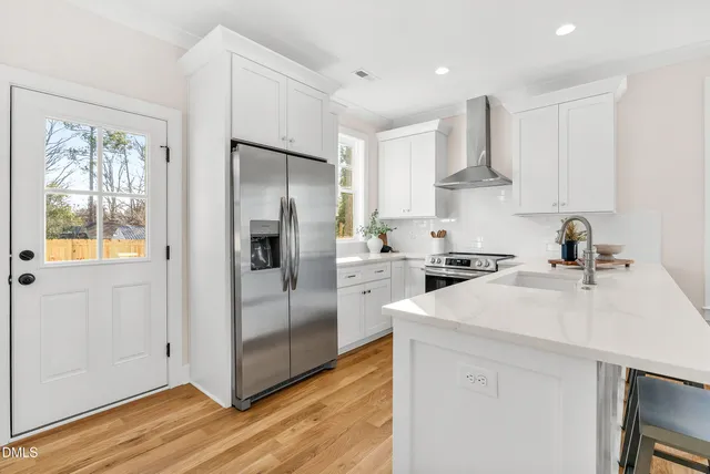 a kitchen with white cabinets and stainless steel appliances