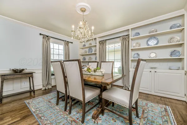 a kitchen with kitchen island granite countertop a table chairs stove and refrigerator
